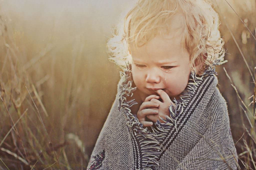 one tear drop at a family portrait shoot as the child is shivering under a blanket for a Tamworth winter