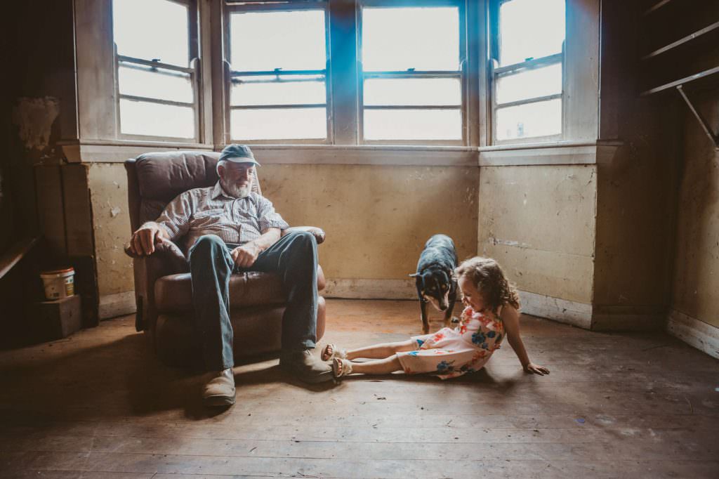 grandpa a dog and his grandchild play in an old family home near Quirindi to make a natural looking photography session