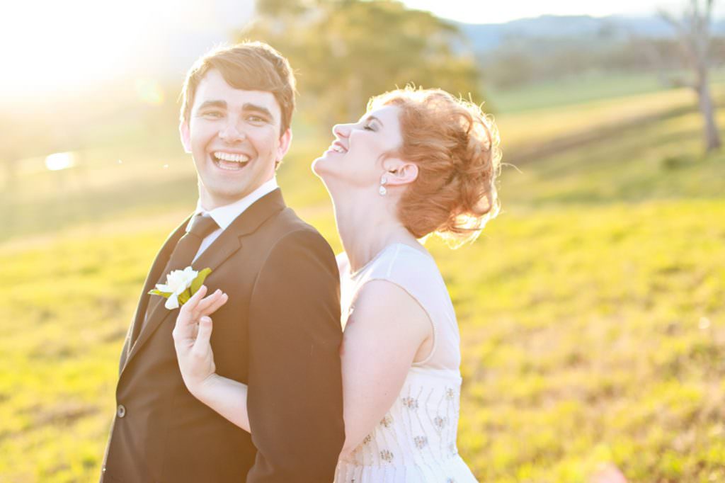 a bride hugs her groom as she snorts of laughter