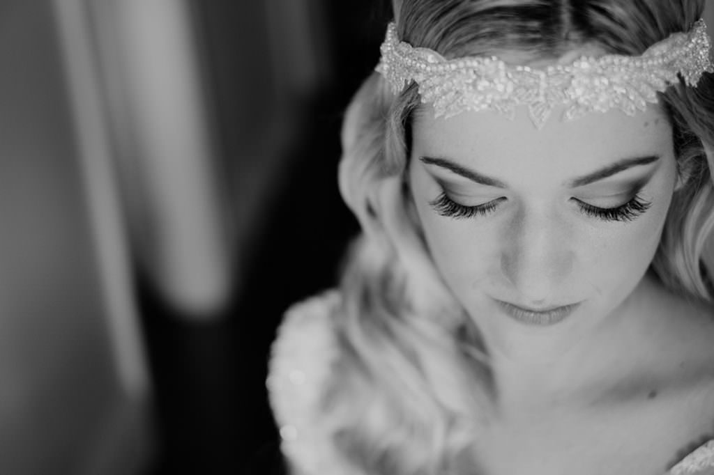 a bride looks down with a vintage lace headband on