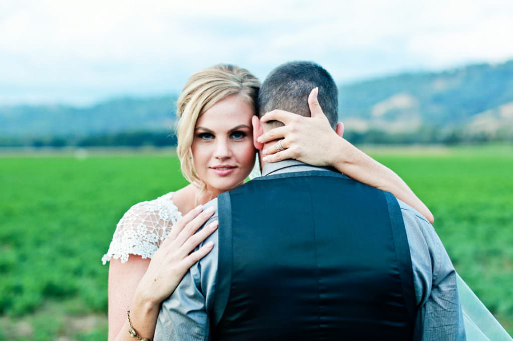 aa bride looks to her Tamworth photographer as she cradles her husbands head in her hand in the dungowan valley
