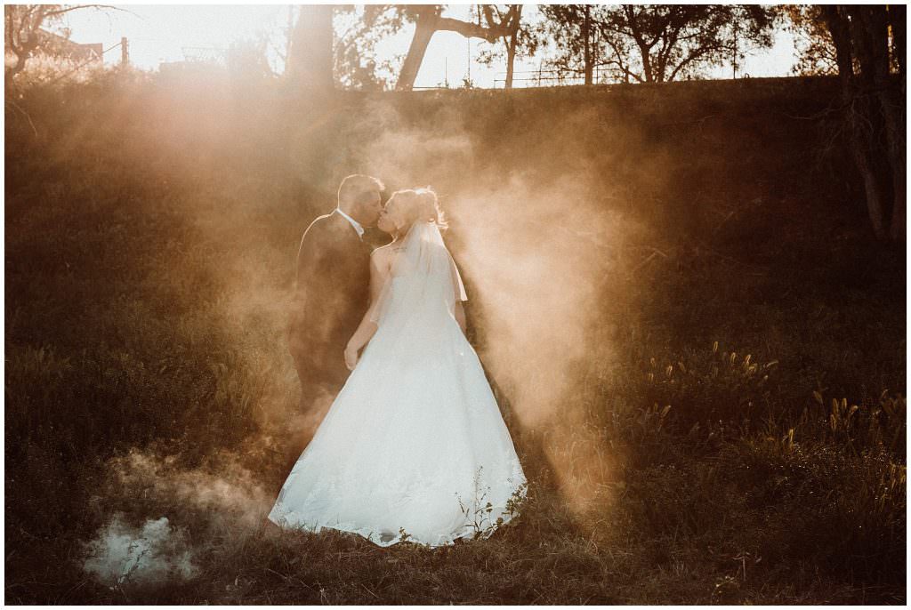 kisses and smoke bobs as the sun sets in the background for a great lighting effect for a Tamworth wedding