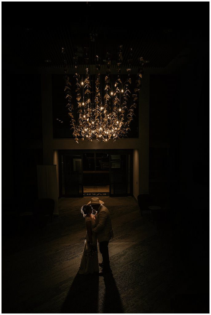 The mecure wedding function centre as couple stand under an incredible chandelier