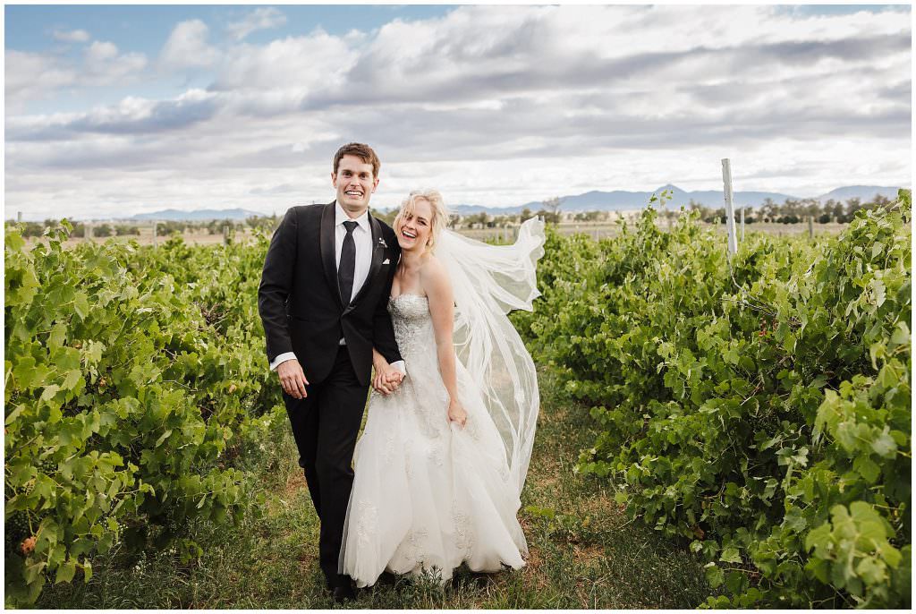 running and laughing amongst the vines a bride and groom at Tangarratta vineyards