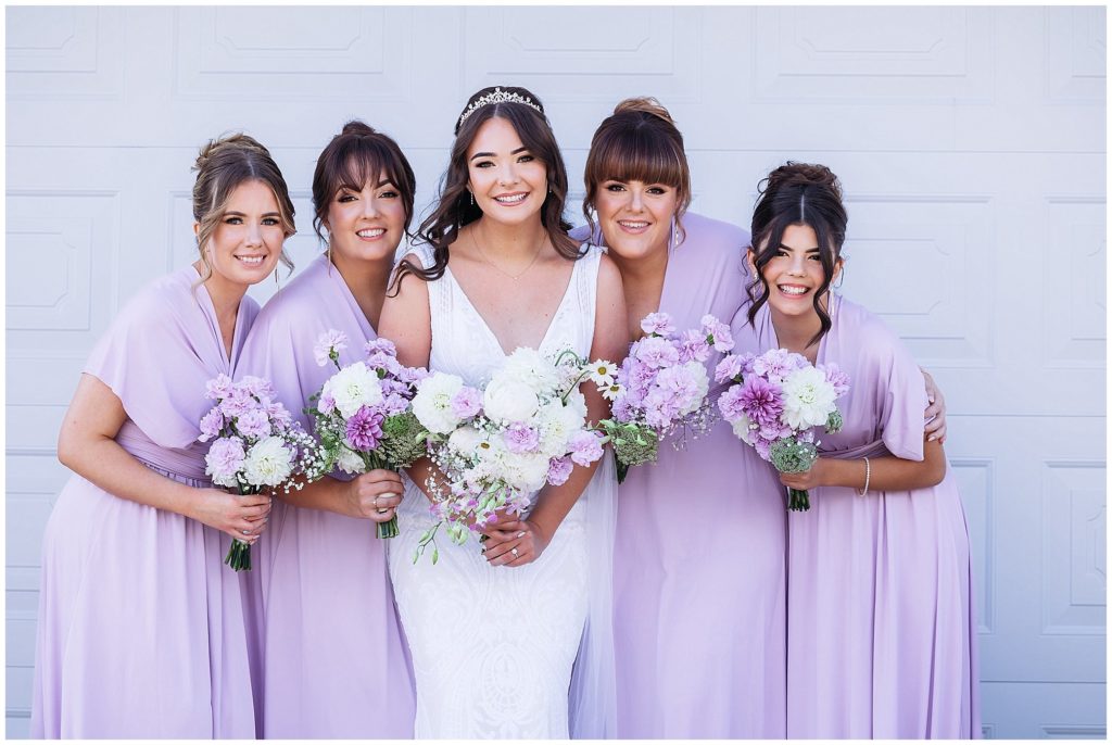 a bride and her bridesmaids who are wearing pink hold their flowers by posies florist Tamworth