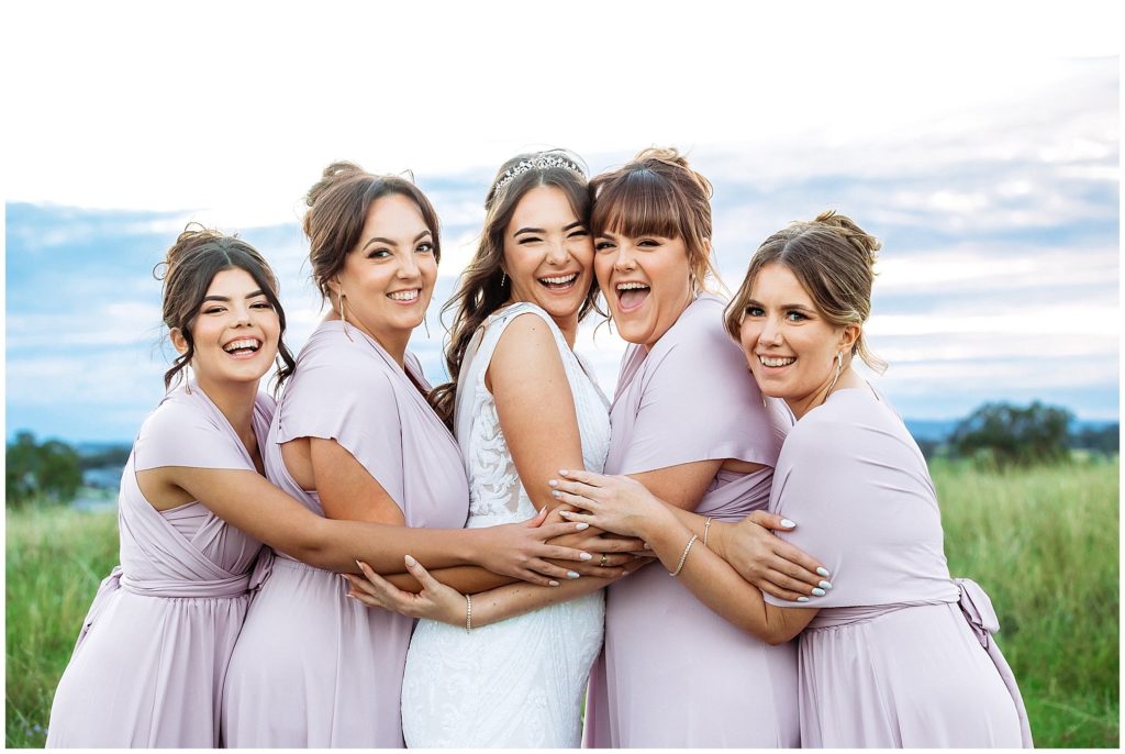 girls and giggles amongst green grass for bridemaids