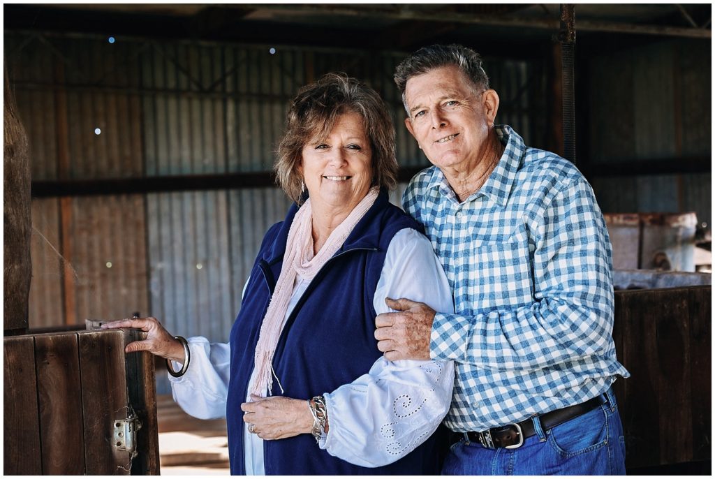 husband and wife in a shearing shed hold onto each other