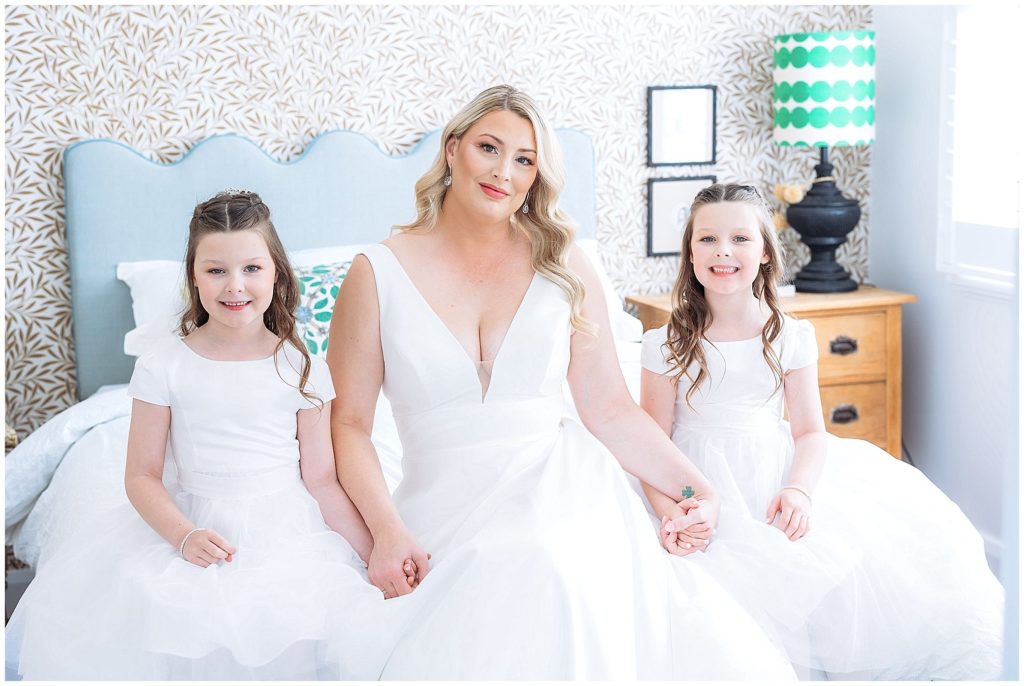 a bride holds her twins hand as she sits on a bed at Querencia airnbn east tamworth