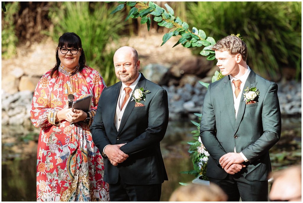 The pavillion function centre tamworth a groom looks at his bride coming down the aisle as celebrant weddings by donna looks on