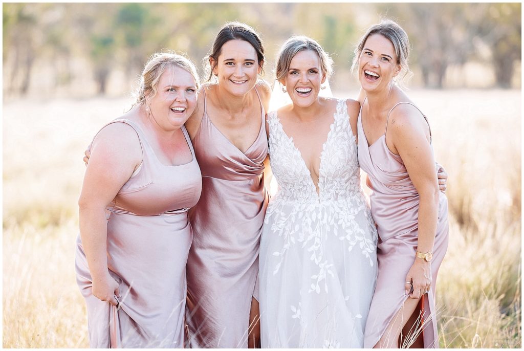 wedding photos in the long grass at Dathem park woolshed girls laughing & smiling real laughs
