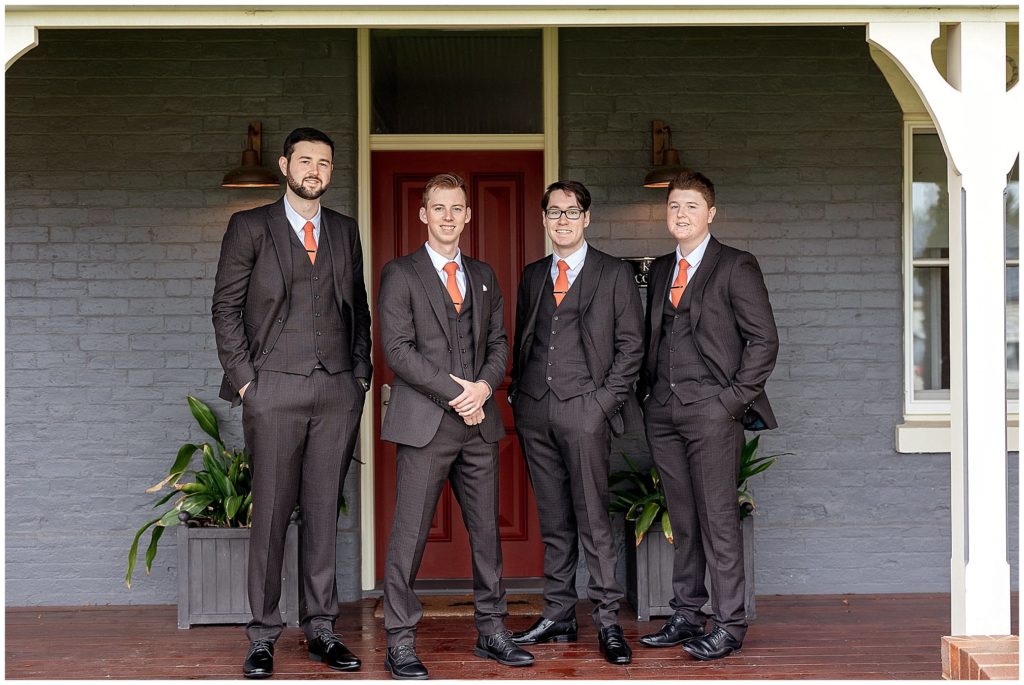 groomsmen in orange ties before they go to the ceremony