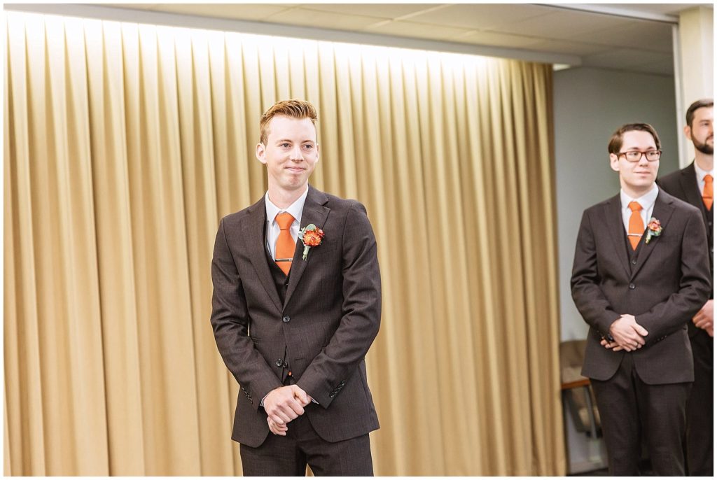 A groom smiles at his bride