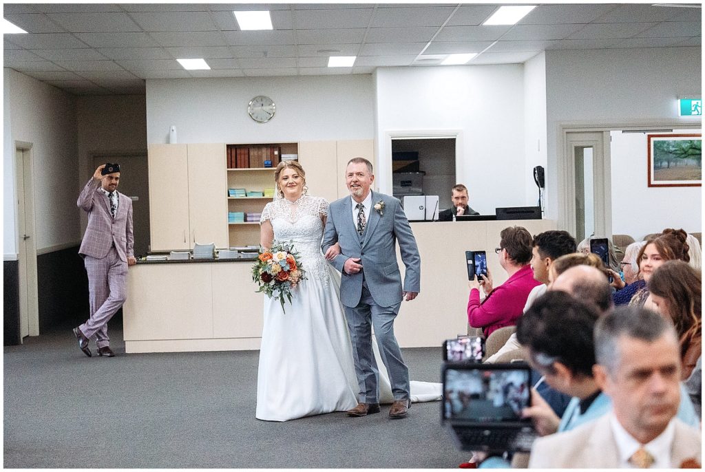 a dad and bride walk down the aisle