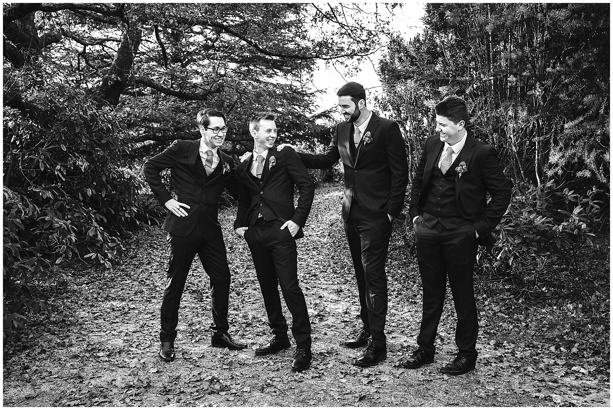 grooms men congratulate the groom in a black and white photo at rock abbey gardens uralla