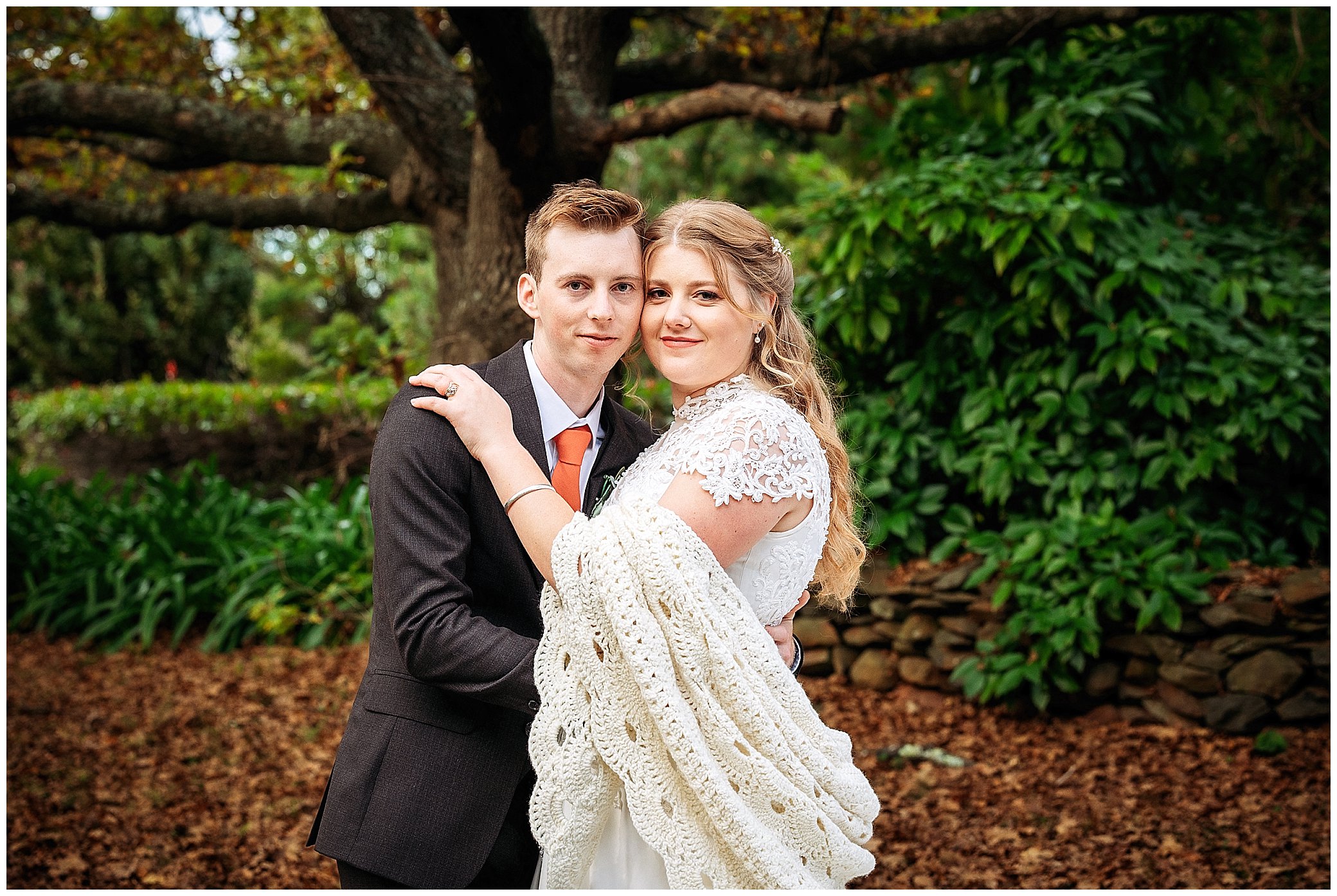 a shawl and a cuddle under a big oak tree at rock abbey gardens Uralla for as they look into the camera