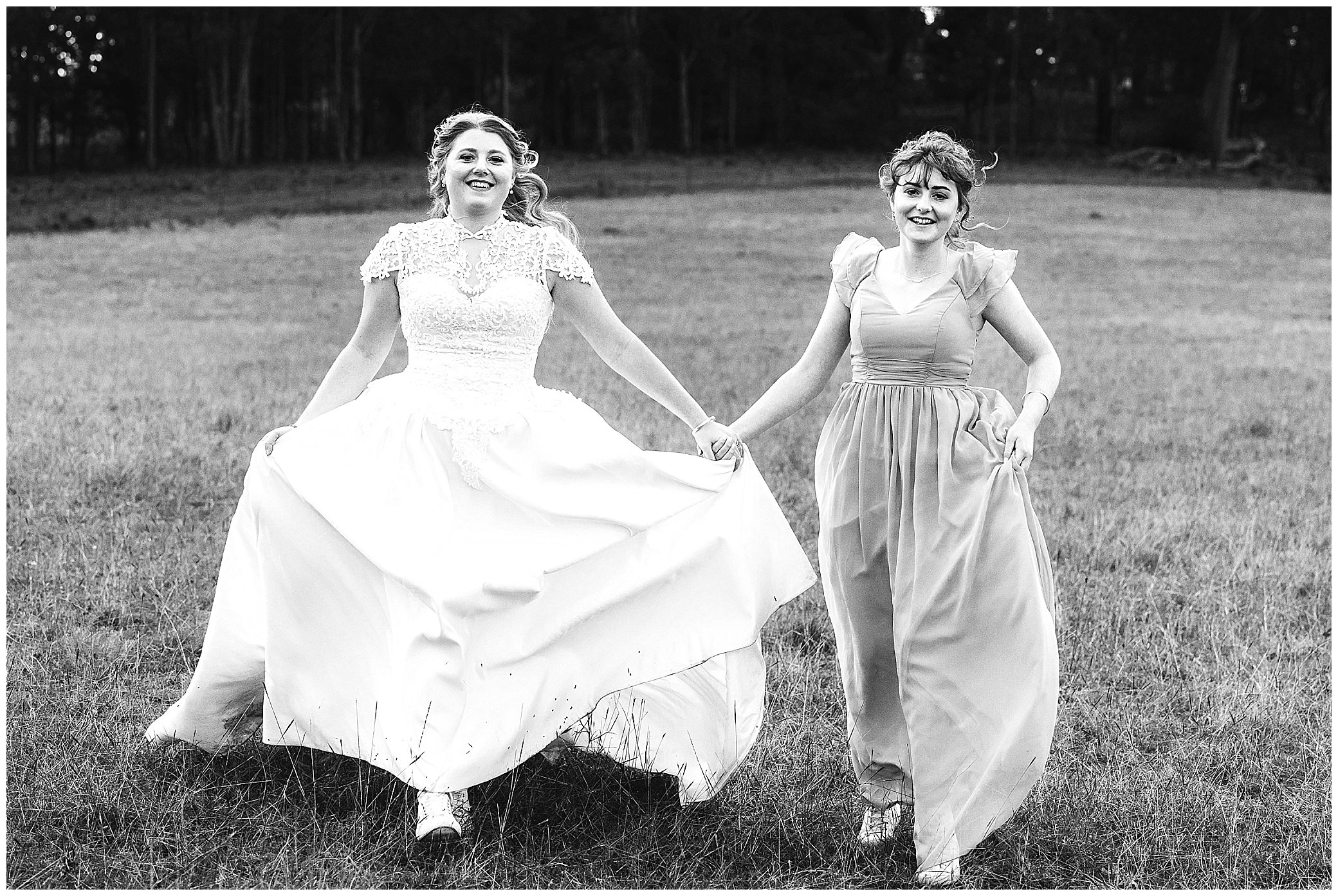 a bride and her sister black and white photo run down the hill