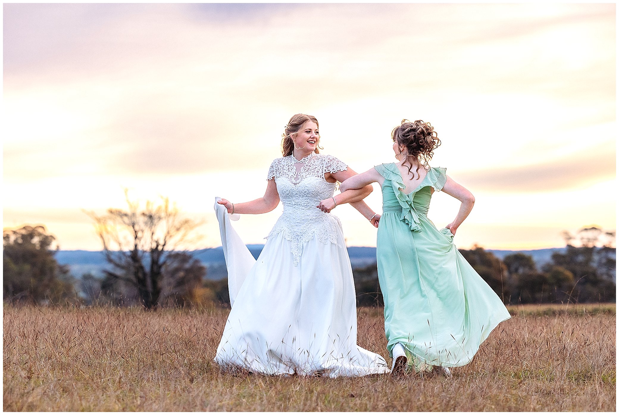 a bride and her sister spin and skip as the sunsets behind them on a wedding day at Rock Abbey Gardens Armidale