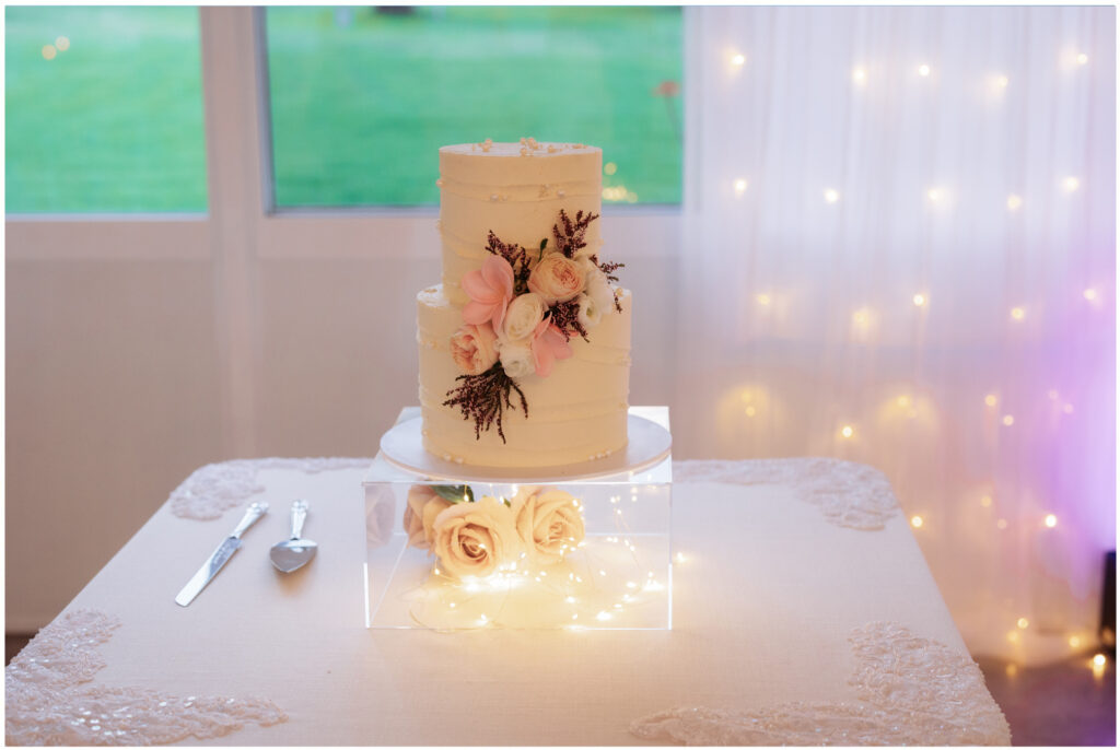 wedding cake white with roses and fairy lights