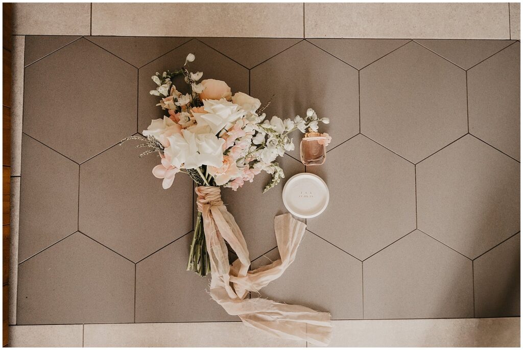 a bouquet by Cobbadah florists with a perfume bottle and a pink piece of material