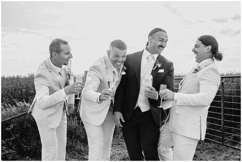 A groom and his attendants share a drink on the farm