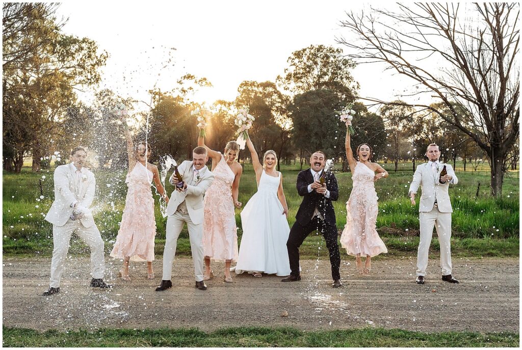 a champagne spray on a wedding day a bridal party have fun