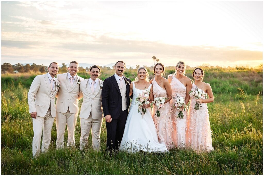 a bridal party at Tangarratta Vineyard in the long golden grass as the sunsets over Tangarratta