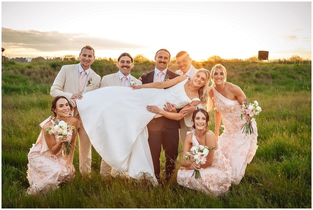 a bridal party at Tangarratta Vineyard in the long golden grass as the sunsets over Tangarratta